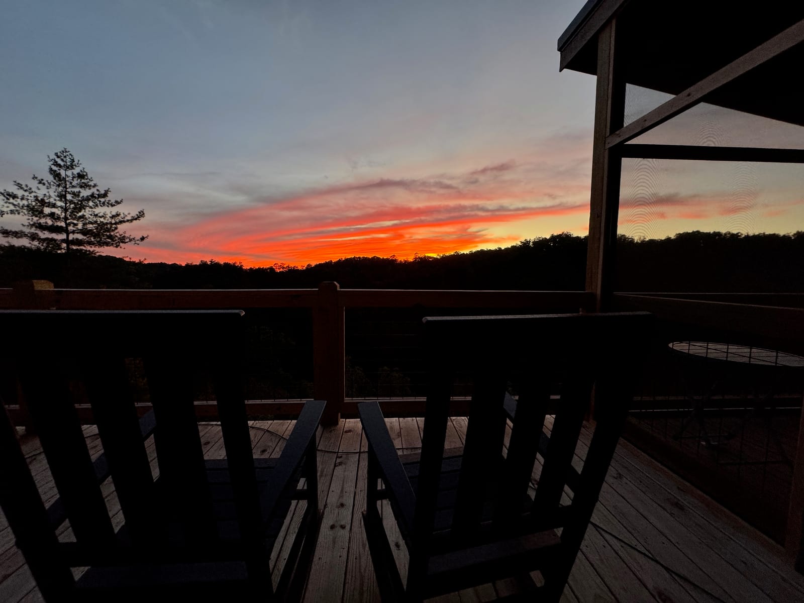 Deck chairs facing a red sunset over the gorge